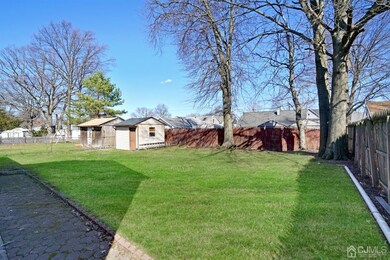 Large fenced in backyard with storage shed.
