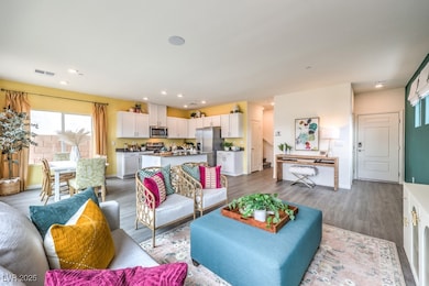 Living area with wood finished floors and recessed lighting. Home is representational only; actual home finishes may vary.