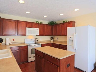 Kitchen. The kitchen offers attractive cherry cabinets, lots of counter space, center island, electric oven/range, microwave and refrigerator, as well as laminate floors.