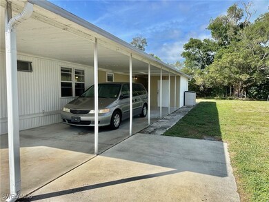 View of parking with a lawn and a carport