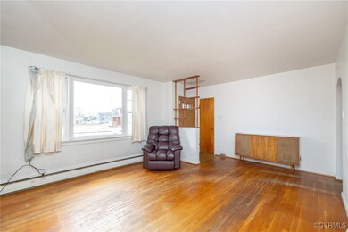 Unfurnished room with a baseboard radiator, arched
