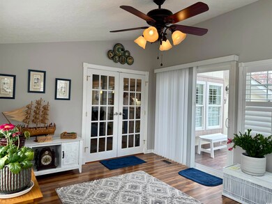 Entry to living room featuring French doors, Montgomery Apple Pergo Flooring, vaulted ceiling