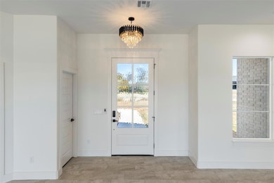 Entryway featuring baseboards and a chandelier