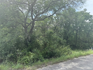 View of asphalt street featuring a view of trees