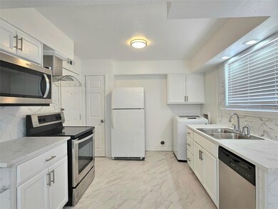 Kitchen featuring white cabinets, appliances with 