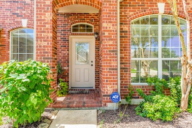 The front step invites you in with a beautiful brick arch and greenery.
