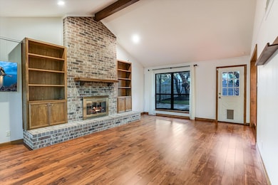 Unfurnished living room with wood finished floors and a fireplace