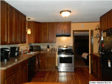Kitchen with stainless steel appliances, new cabinetry, granite counter tops and travertine backsplash