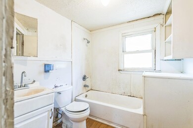 Full bathroom featuring a textured ceiling, vanity