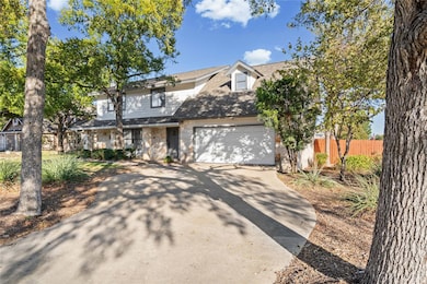 Traditional home featuring driveway and stone siding