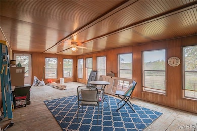 Sunroom featuring hardwood / wood-style floors, plenty of natural light, and wooden walls