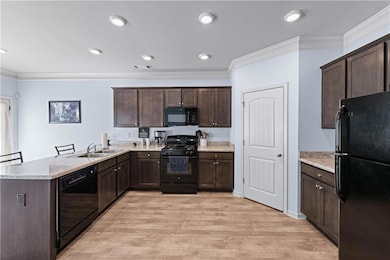 Kitchen with a peninsula, crown molding, dark brow