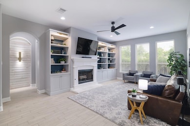 Living area featuring a ceiling fan, a fireplace,