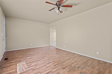 Unfurnished room with wood finished floors and a ceiling fan