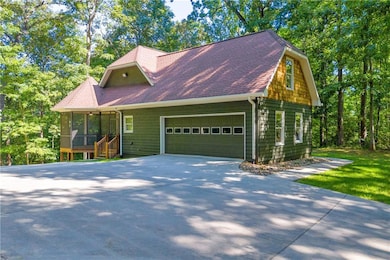 View of front of home with a garage, a sunroom, an