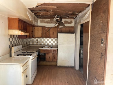 kitchen featuring white appliances, light countertops, tasteful backsplash, dark wood-style flooring, and under cabinet range hood