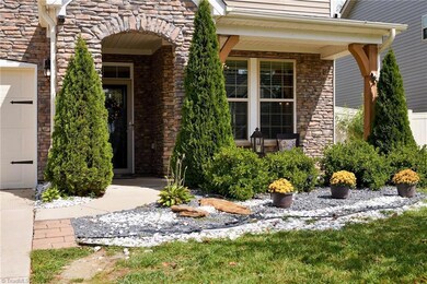 Beautiful stone façade exterior entry to the covered porch with wood beams for an updated modern look!