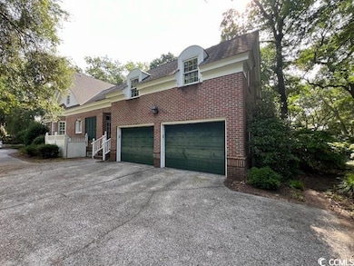 View of side of home featuring brick siding, asphalt driveway, and a garage