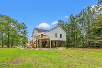 Back of property featuring stairs, a yard, a deck, and a carport