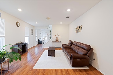 Living room with light wood-type flooring, stairs, recessed lighting, and arched walkways