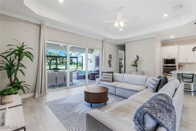 Living area featuring a tray ceiling, a ceiling fa