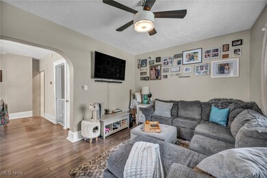 Living room featuring ceiling fan, wood-type flooring, and a textured ceiling