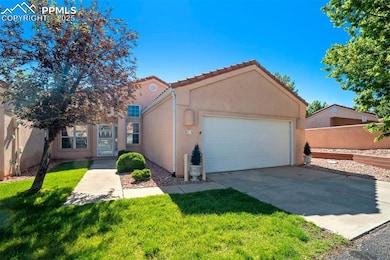 View of front of property featuring stucco siding, an attached garage, driveway, and a tiled roof