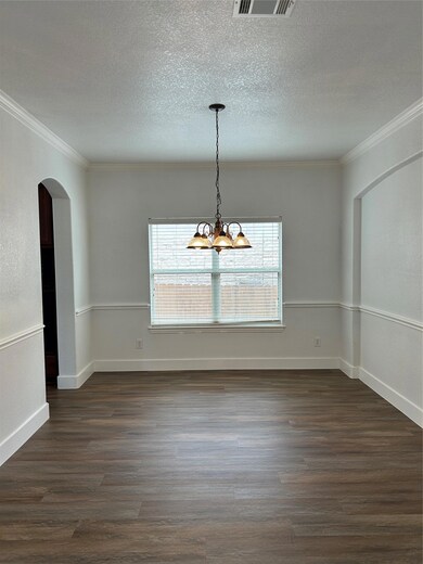 Unfurnished room featuring arched walkways, a cha