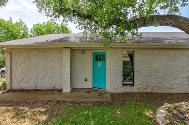 Doorway to property with roof with shingles and s
