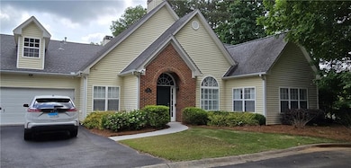 View of front facade with an attached garage, a ch