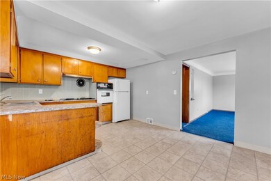 Kitchen with sink, light carpet, tasteful backsplash, and white appliances