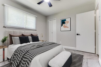 Bedroom with light colored carpet, ceiling fan, a 