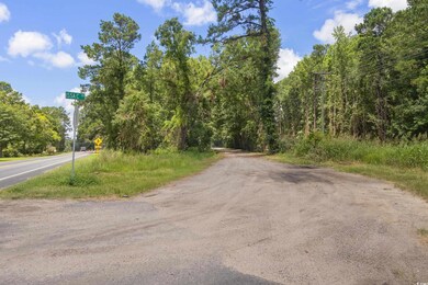 View of asphalt street with a wooded view and traffic signs