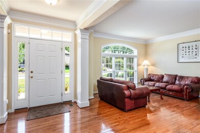 Wide entry foyer with hardwood floors and crown molding.