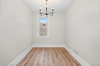 Unfurnished dining area featuring light wood-style flooring and a chandelier