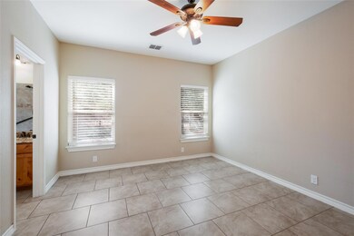 Empty room featuring healthy amount of natural light, ceiling fan, and light tile patterned floors