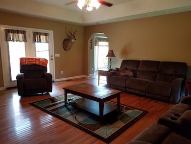 19x18 Living Room adorned with hardwood floors, a trey ceiling, and lots of windows for fresh outdoor light.