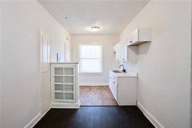 Laundry room featuring dark wood-style flooring and baseboards