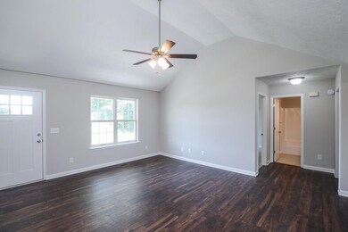 Living room with vaulted ceilings. Whole house has new paint and flooring.