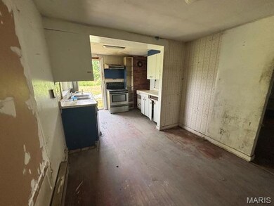 Kitchen with stainless steel electric range oven, light countertops, white cabinetry, and range hood