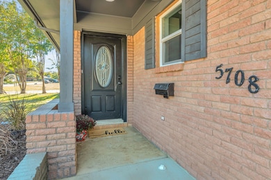 Doorway to property with a porch and brick siding