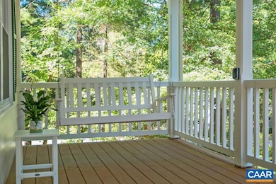 Freshly stained, covered front porch with charming swing.
