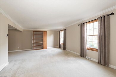 Carpeted empty room featuring ornamental molding