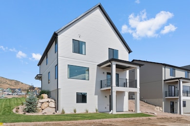 Rear view of house featuring a patio area, a lawn, a balcony, and a mountain view