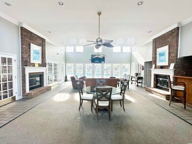 Carpeted dining room with ceiling fan, crown molding, and a fireplace
