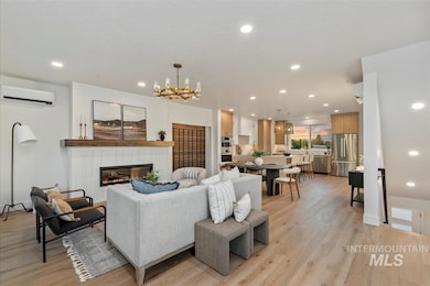 Living area featuring recessed lighting, a tiled fireplace, light wood finished floors, a wall unit AC, and a chandelier
