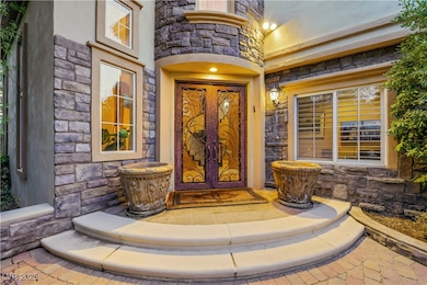 Property entrance featuring stone siding and frenc