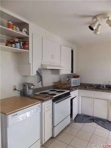 Tile floored kitchen with granite countertops, ele