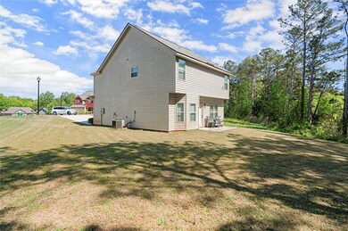 Rear view of property featuring a lawn, a patio ar