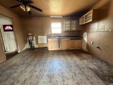 Kitchen with ceiling fan, sink, and a textured cei